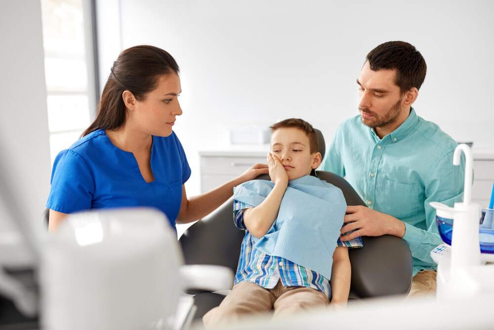 Same-day emergency dentist in Naperville. Child with toothpain at dental office with dad and dentist